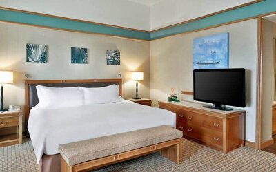 Queen room with chairs, desk and sliding doors at the Hilton Yaounde.