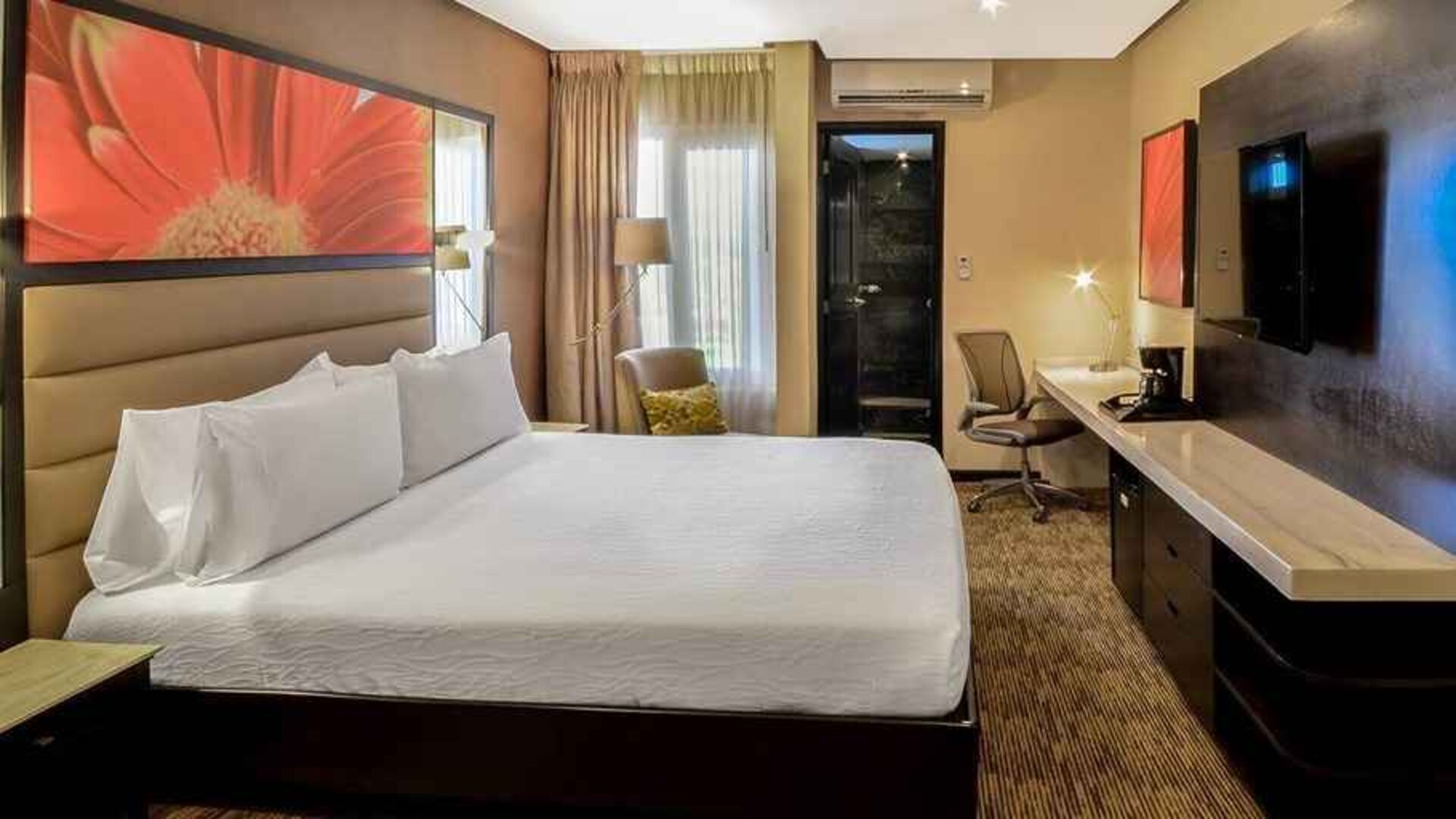 delux king room with TV, desk, and chair at Hilton Garden Inn Guatemala City.