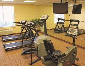 Fitness room with a selection of cardio equipment and workout facilities designed to support guests' health and wellness needs during their stay.