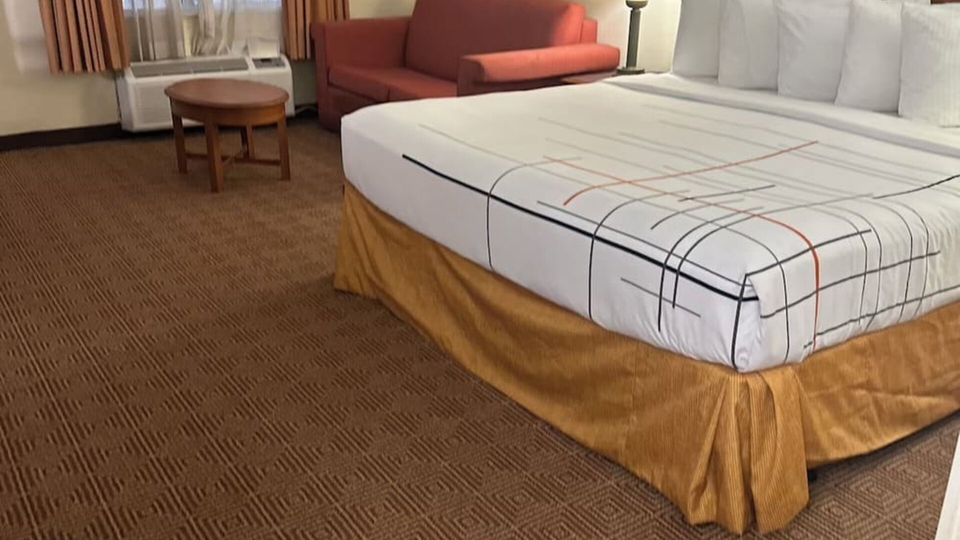 Spacious guest room with a king-size bed, seating area, and ample floor space, offering comfort and convenience for both business and leisure travelers.