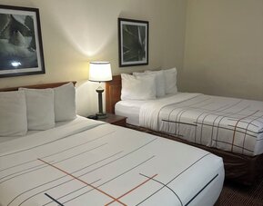 Guest room with two beds, comfortable furnishings, and practical amenities, making it an ideal accommodation choice for families or groups staying at La Quinta Inn & Suites By Wyndham Sawgrass Mills.
