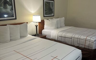 Guest room with two beds, comfortable furnishings, and practical amenities, making it an ideal accommodation choice for families or groups staying at La Quinta Inn & Suites By Wyndham Sawgrass Mills.