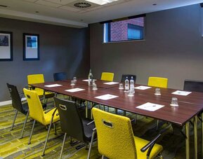 Professional meeting room with plush yellow chairs. 
