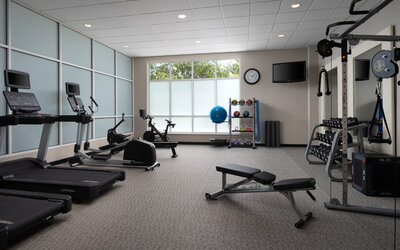 Modern fitness center featuring cardio equipment, strength-training machines, free weights, and workout space at Embassy Suites By Hilton Charleston Airport Convention Center.