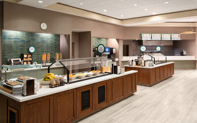 Complimentary breakfast buffet featuring a variety of hot and cold selections, fresh fruit, beverages, and spacious serving stations at Embassy Suites By Hilton Charleston Airport Convention Center.