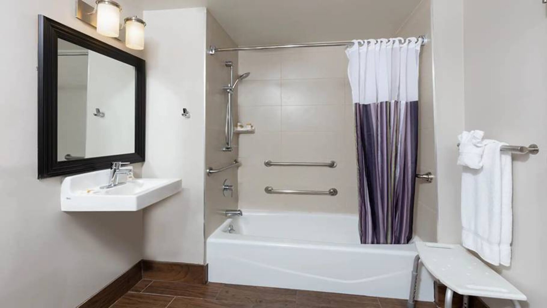 Guest bathroom with shower and tub at La Quinta Inn & Suites By Wyndham New York City Central Park.