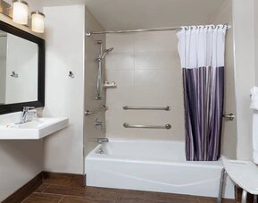 Guest bathroom with shower and tub at La Quinta Inn & Suites By Wyndham New York City Central Park.
