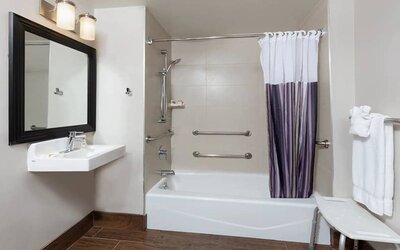 Guest bathroom with shower and tub at La Quinta Inn & Suites By Wyndham New York City Central Park.