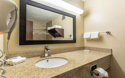 Clean and spacious guest bathroom at Red Roof PLUS+ & Suites Houston - IAH Airport SW.