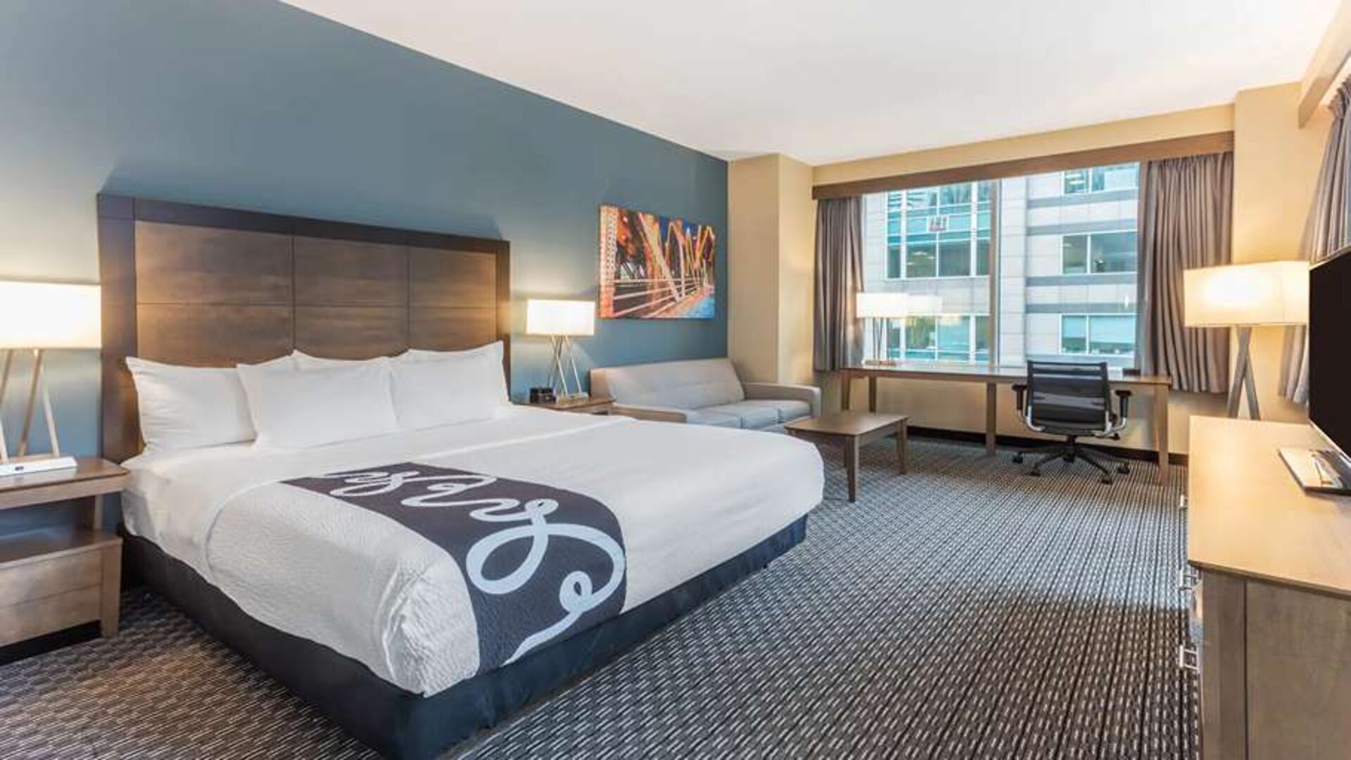 King bedroom with desk and sofa at La Quinta Inn & Suites By Wyndham Chicago Downtown.