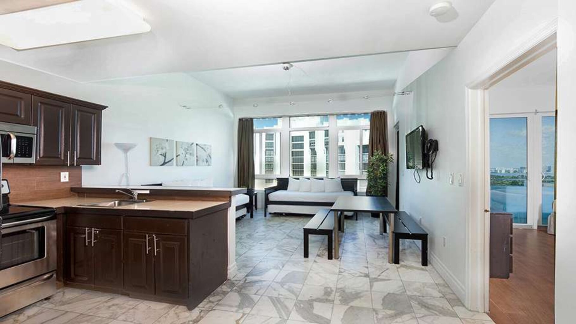 Living room with kitchenette and workspace at New Point Miami.