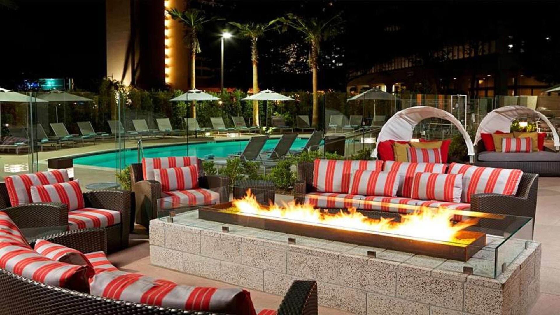 Beautiful outdoor patio by the pool with firepit at Residence Inn By Marriott LAX Airport.