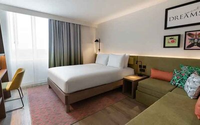 Queen bedroom with corner sofa at the Hampton by Hilton Istanbul Arnavutkoy.