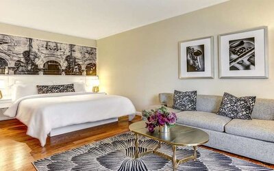 Hotel room with sofa and king bed at Avenue Of The Arts Hotel.