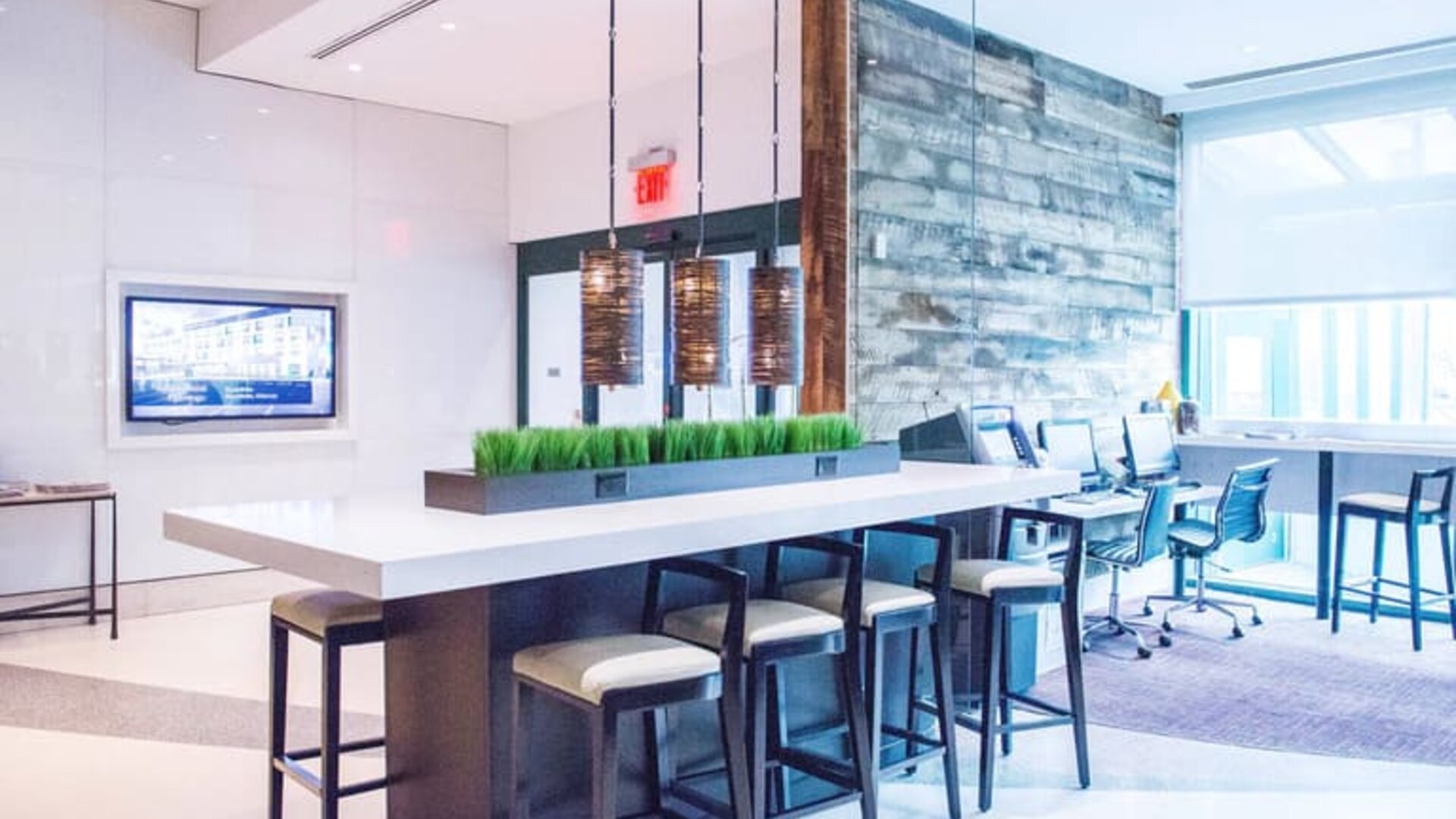 Comfortable open plan seating with plug points for laptops ideal for working remotely at Courtyard By Marriott New York JFK Airport.