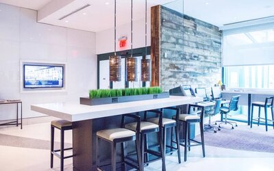 Comfortable open plan seating with plug points for laptops ideal for working remotely at Courtyard By Marriott New York JFK Airport.