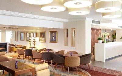 Comfy and communal seating with coffee tables near the hotel entrance.