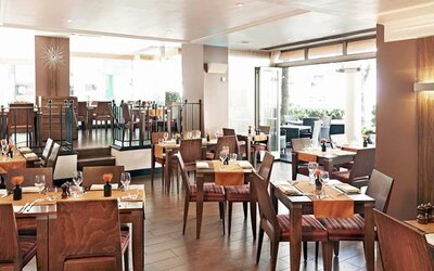 Indoor seating with tables for two or four diners, with large windows and a window floor.