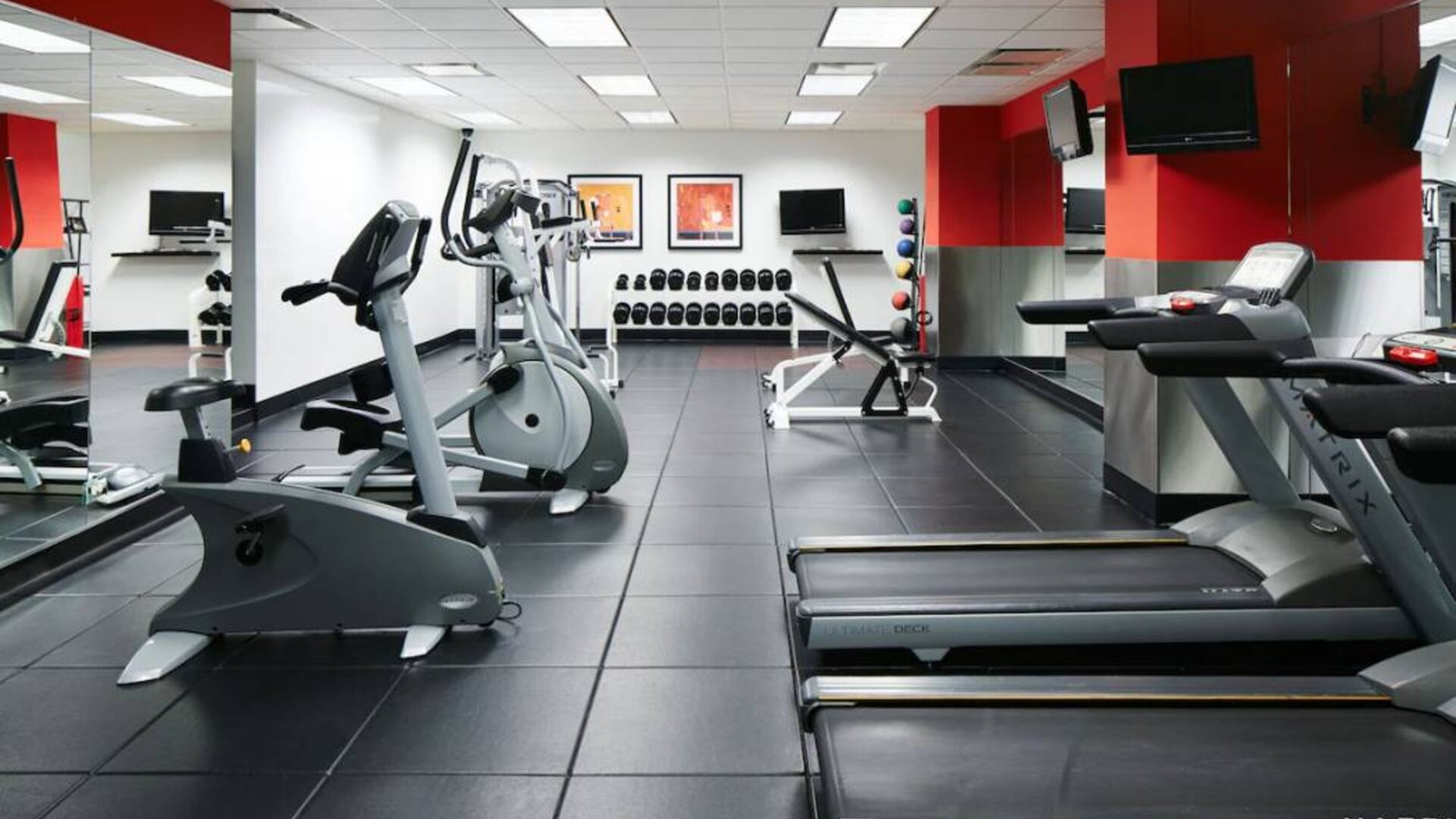 The hotel’s fitness center is equipped with multiple exercise machines, benches, and weights.
