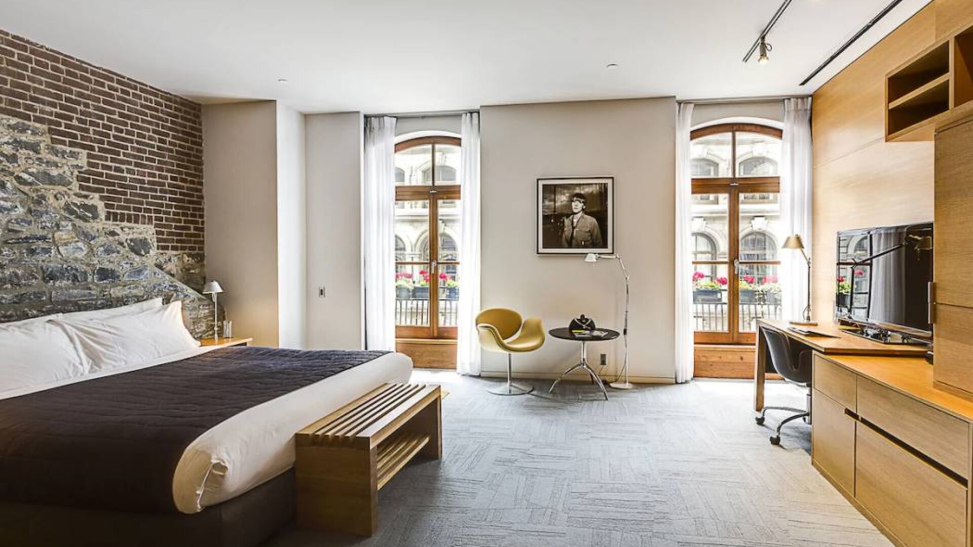 Double bed guest room in Hotel Gault, furnished with workspace desk and chair, plus large windows.