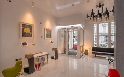 Entrance to the Victoria Inn, with a sleek white marble flooring, self-serve kiosks and chic furniture, fixtures.