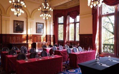 The River Room of The Royal Horseguards Hotel, a meeting space decorated with wood panels and chandeliers.