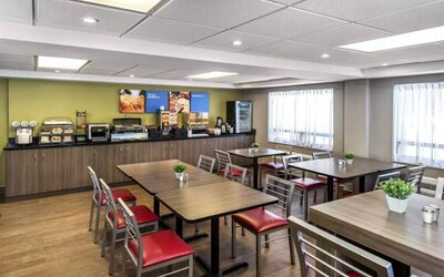 The Comfort Inn Saskatoon’s breakfast area has a hard floor and assorted table sizes.