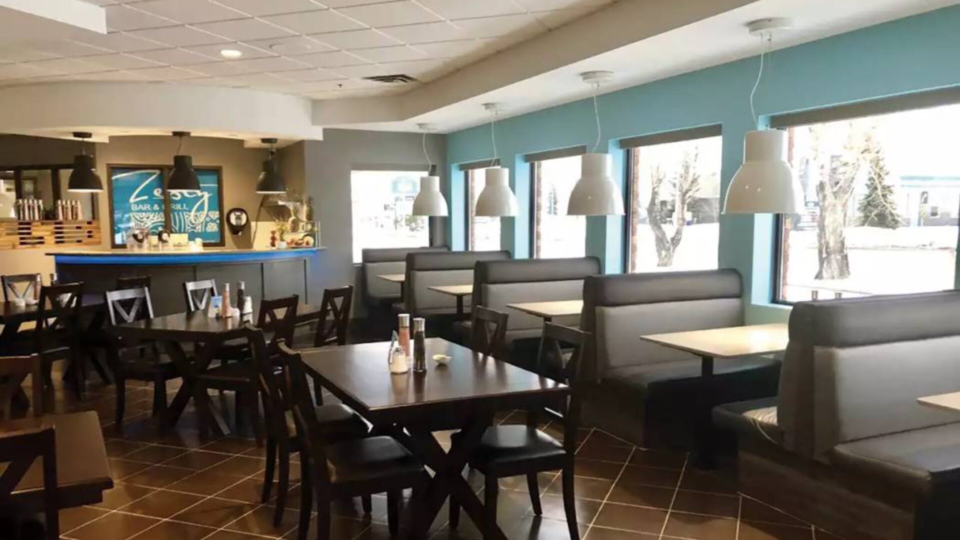 The hotel’s on-site restaurant has hard floors, large windows, and tables for four.