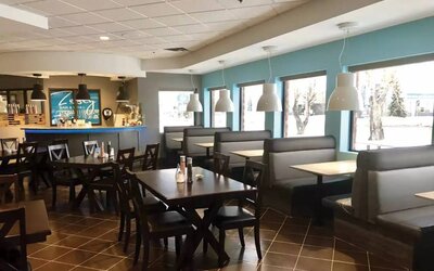 The hotel’s on-site restaurant has hard floors, large windows, and tables for four.