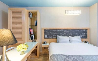 Double bedroom at TRYP By Wyndham Times Square South, including bookcase and lamp.