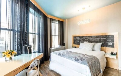 Room at the TRYP By Wyndham Times Square South containing desk, double bed, and large windows.