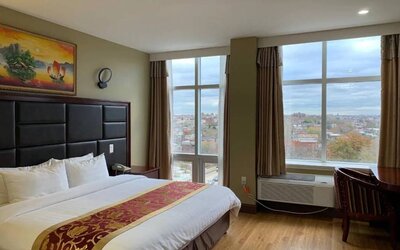 Guest room at the Queens Hotel, with double bed and large windows.