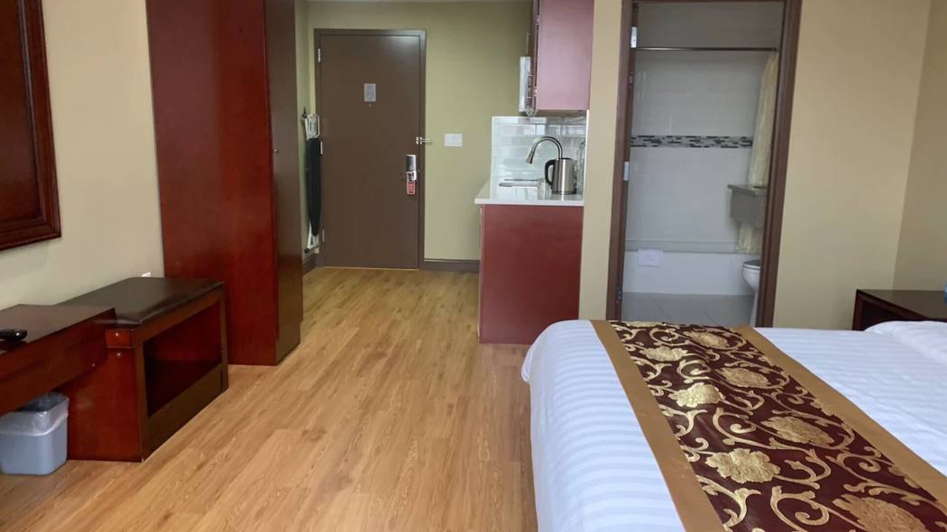 A Queens Hotel guest room, featuring a kitchenette area, and ensuite bathroom.