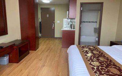A Queens Hotel guest room, featuring a kitchenette area, and ensuite bathroom.
