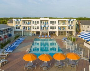Outdoor pool with lounge chairs and umbrellas at Sea Crest Beach Hotel.
