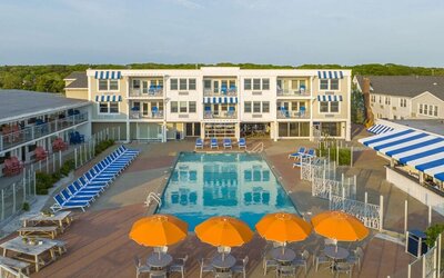 Outdoor pool with lounge chairs and umbrellas at Sea Crest Beach Hotel.