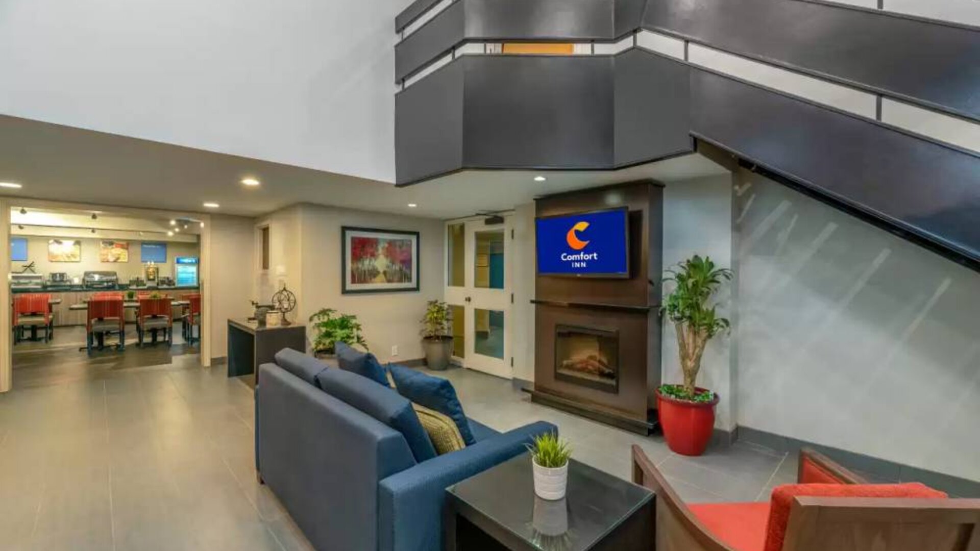 Lounge in the Comfort Inn Winnipeg Airport lobby, with comfy seating and cozy fireplace.