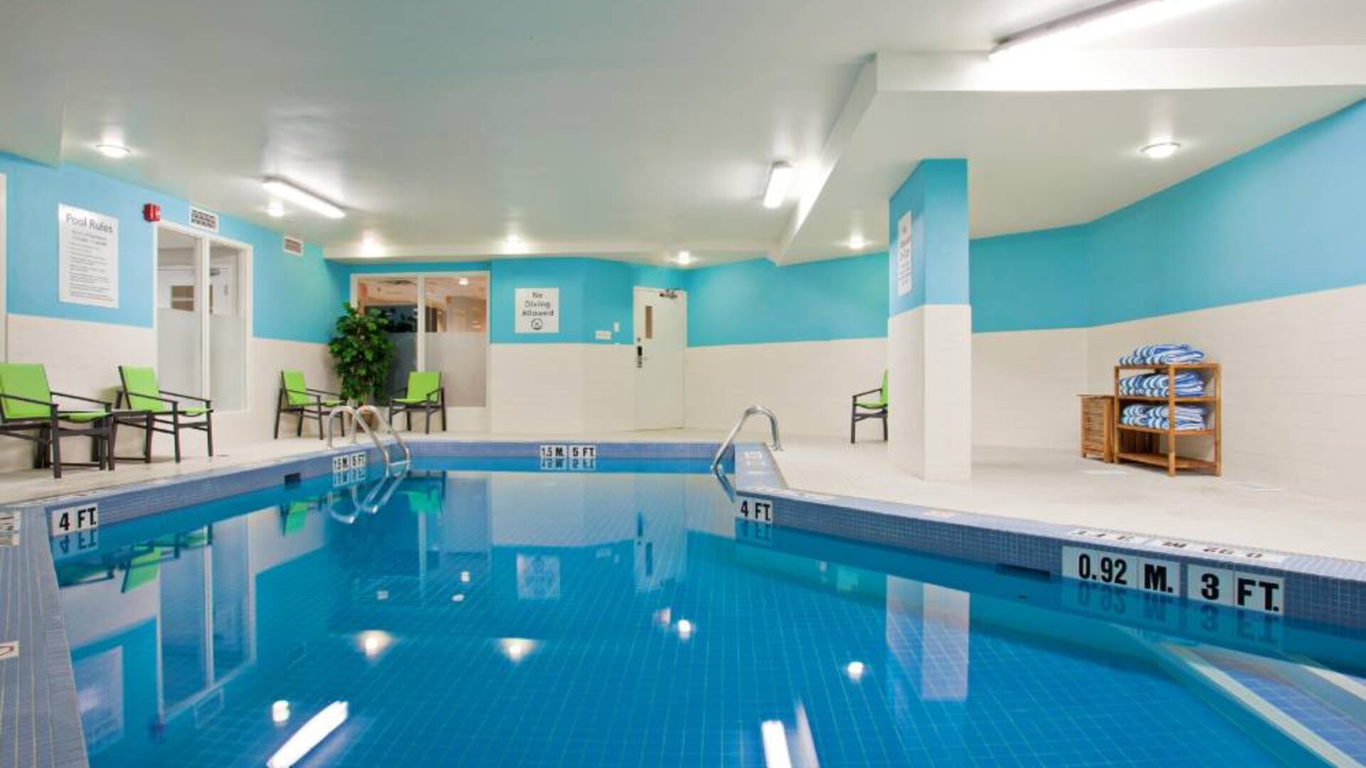 The hotel’s indoor swimming pool has nearby chairs and towels.