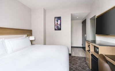 Double bed guest room in the DoubleTree Times Square South, with art on the wall and large TV.