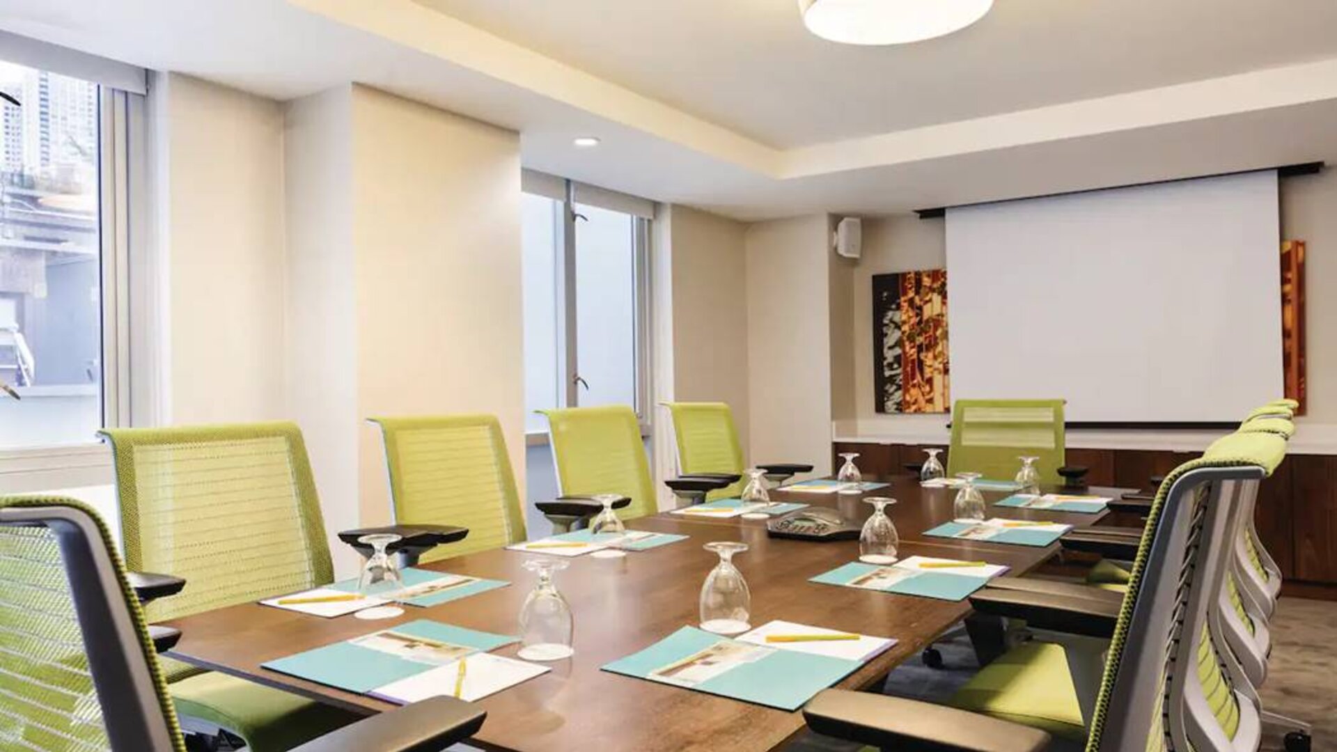 A meeting room in the Hilton Garden Inn Midtown East, with long wooden table and space for ten attendees.