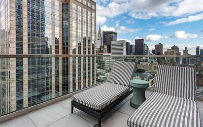 Panoramic city views from a guest room balcony in The Draper, Ascend Hotel Collection, with a pair of loungers.