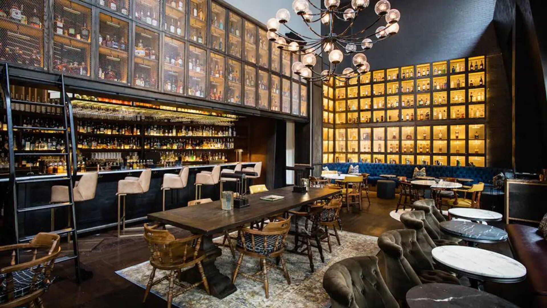 The bar and lounge of Hyatt Union Square New York, with hard floor, bar stools, and range of table sizes.