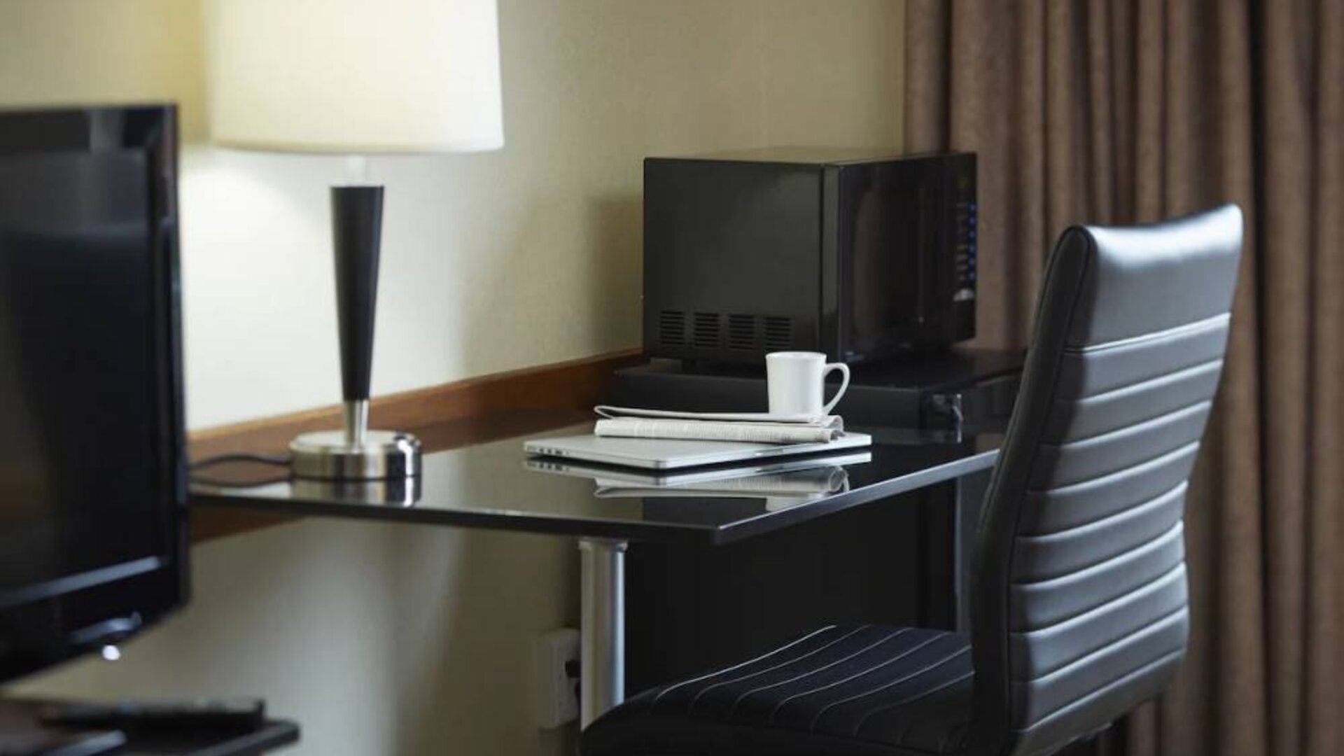 An in-room workspace at the Comfort Inn Belleville, including desk, chair, and lamp.