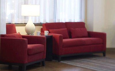 The hotel lobby lounge has comfortable seating and is brightly lit.