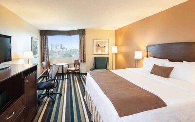 Best Western Plus Winnipeg Airport guest room, including large bed, and desk and chair for working.