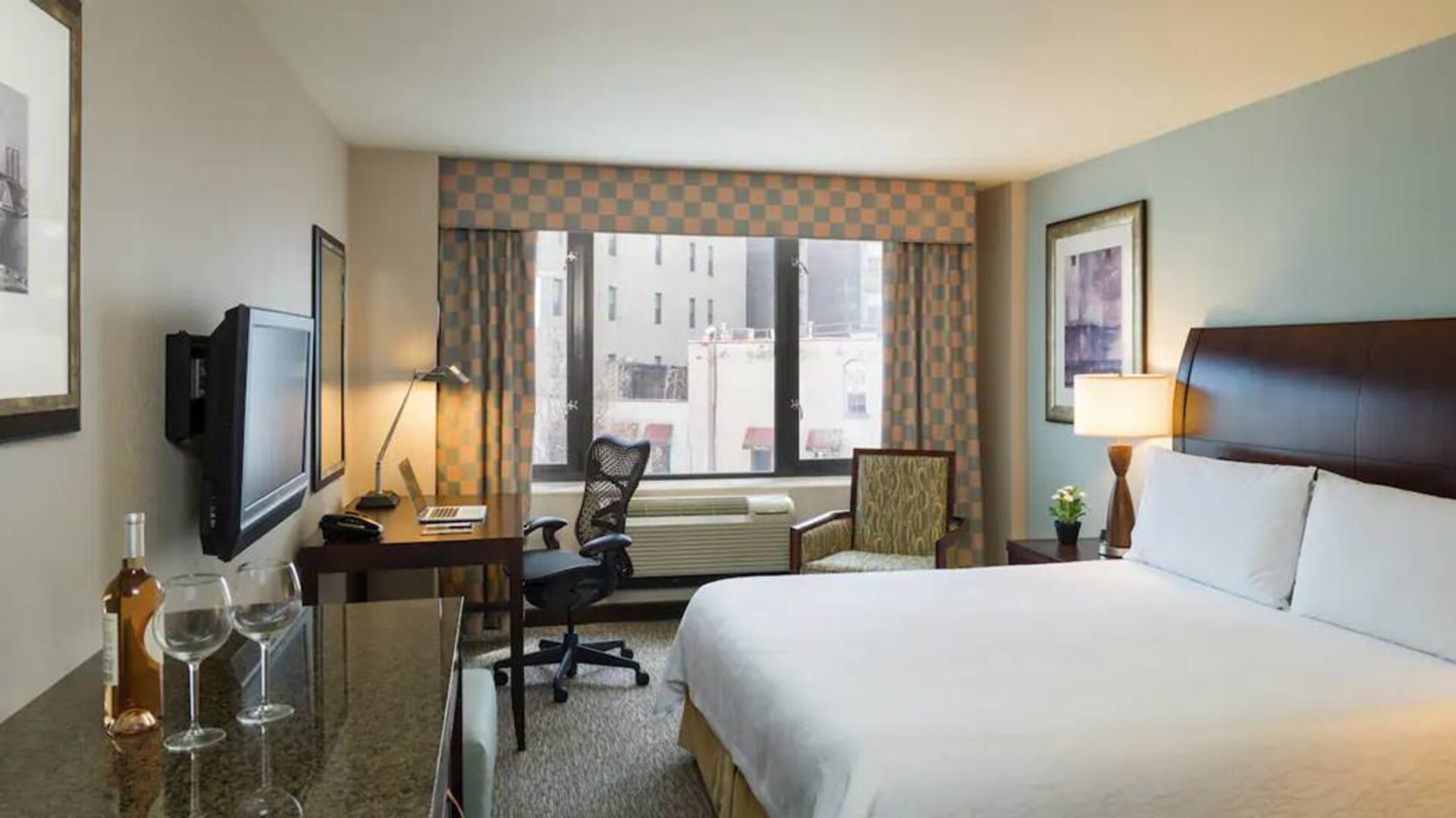 Guest room in the Hilton Garden Inn Tribeca, furnished with large bed, desk and chair for working, and TV.