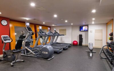 The hotel fitness center, which is equipped with weights, an exercise bench, and multiple machines.