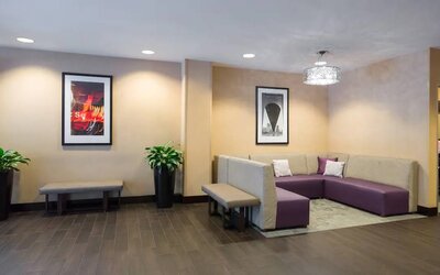 Hampton Inn Times Square South’s lobby lounge, with art on the walls and comfortable sofa seating.