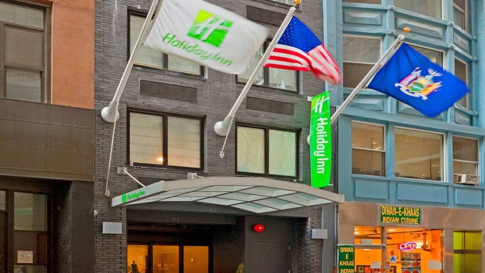 Exterior shot of the Holiday Inn Express Wall Street and its trio of fluttering flags.