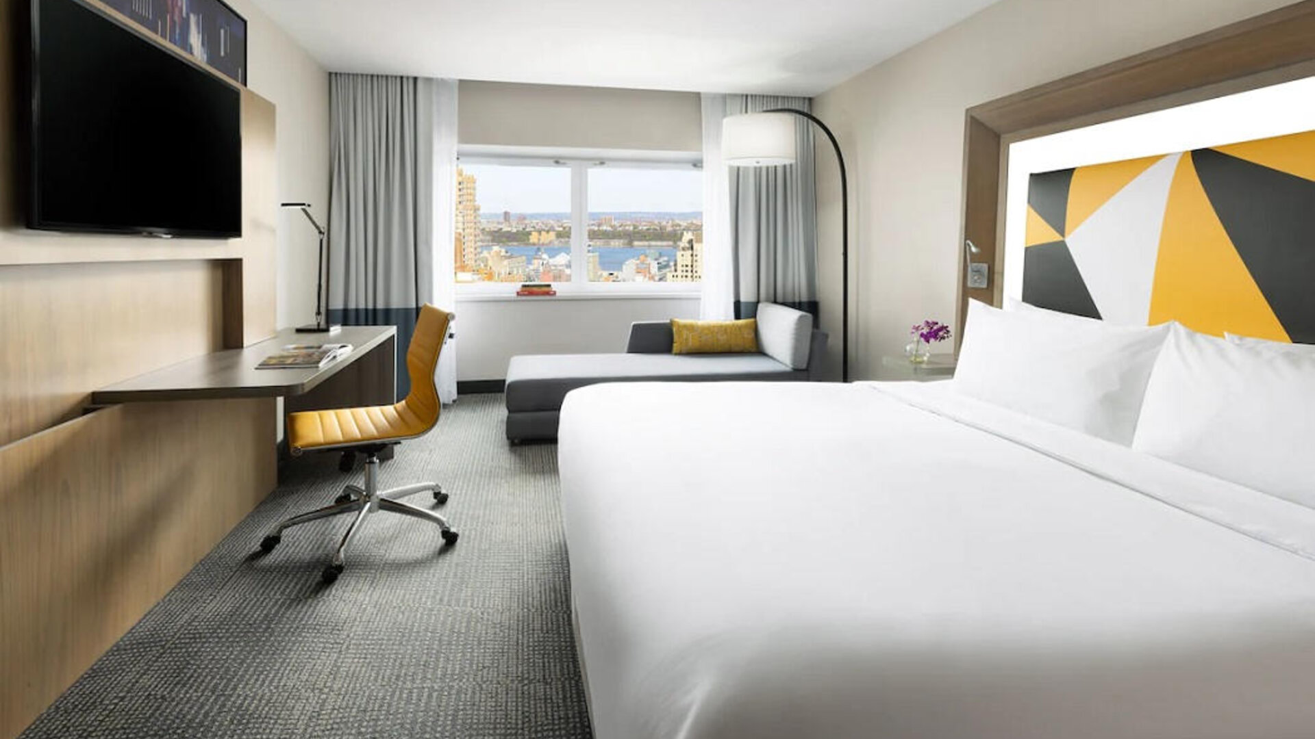 Spacious day use room with TV, business desk, and couch at M Social Hotel Times Square.
